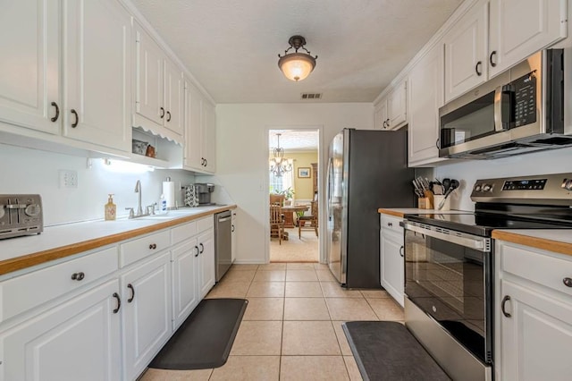 435 Flowering Trl, Grayson, GA 30017 - kitchen with stainless steel appliances, white cabinets, light countertops, a sink, and light tile patterned floors