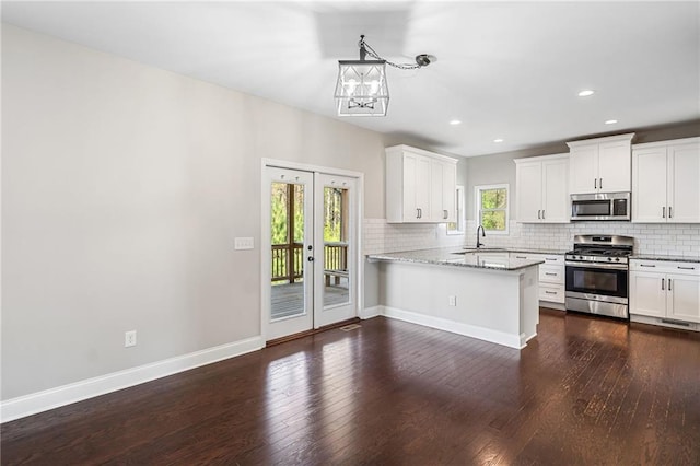 399 Cobblestone Trl, Dallas, GA 30132 - kitchen featuring a chandelier, dark wood-style floors, backsplash, stainless steel appliances, and a sink