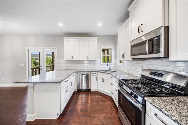 399 Cobblestone Trl, Dallas, GA 30132 - kitchen featuring white cabinets, a sink, dark wood-style flooring, appliances with stainless steel finishes, and a peninsula