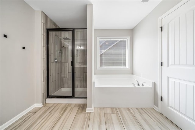 399 Cobblestone Trl, Dallas, GA 30132 - bathroom featuring a shower stall, a bath, and baseboards