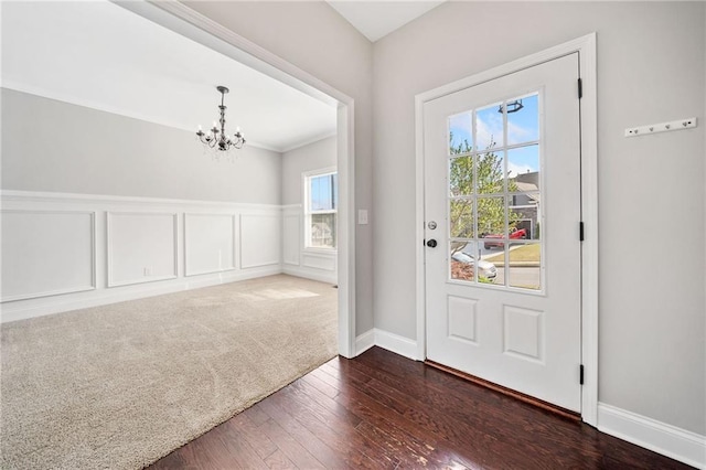 399 Cobblestone Trl, Dallas, GA 30132 - doorway to outside featuring baseboards, an inviting chandelier, wainscoting, and dark wood finished floors