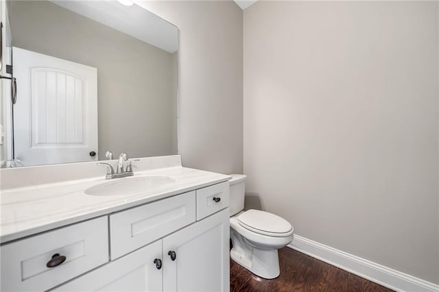 399 Cobblestone Trl, Dallas, GA 30132 - half bathroom featuring toilet, baseboards, vanity, and wood finished floors