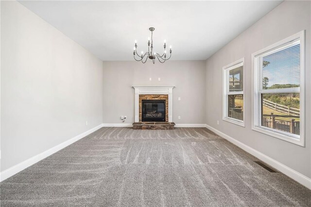 399 Cobblestone Trl, Dallas, GA 30132 - unfurnished living room featuring carpet, a stone fireplace, visible vents, baseboards, and a notable chandelier