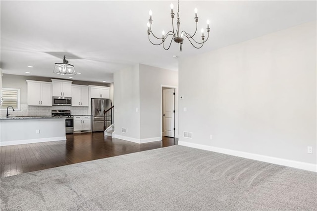 399 Cobblestone Trl, Dallas, GA 30132 - unfurnished living room featuring an inviting chandelier, visible vents, a sink, stairs, and baseboards