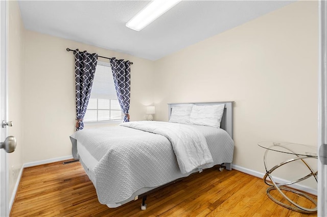 bedroom featuring baseboards and wood finished floors