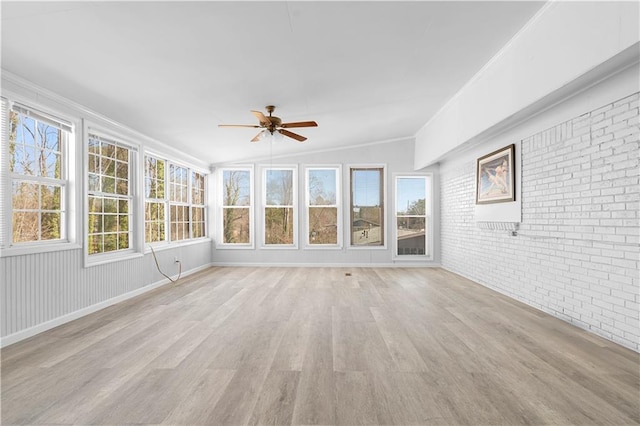 unfurnished sunroom featuring a ceiling fan and vaulted ceiling