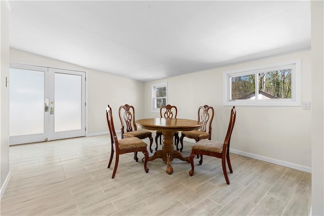 dining area with french doors, light wood-style floors, and baseboards