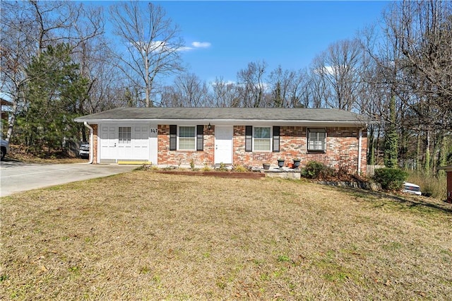 ranch-style home with driveway, brick siding, and a front yard