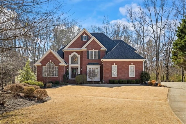 view of front of home with brick siding and a front lawn