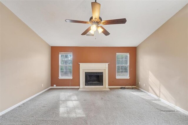 unfurnished living room featuring carpet flooring, a wealth of natural light, ceiling fan, and vaulted ceiling