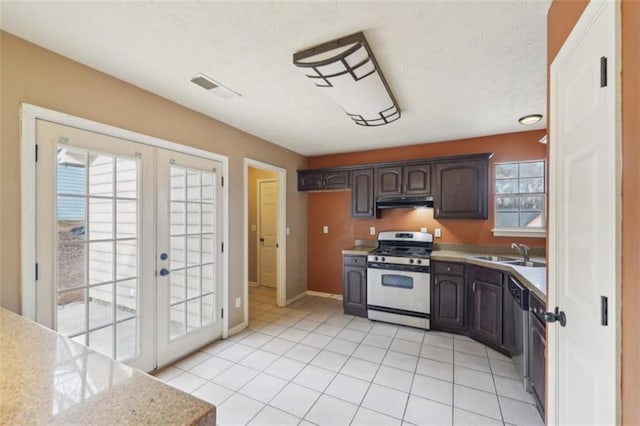 kitchen featuring sink, light tile patterned floors, stainless steel appliances, dark brown cabinetry, and french doors