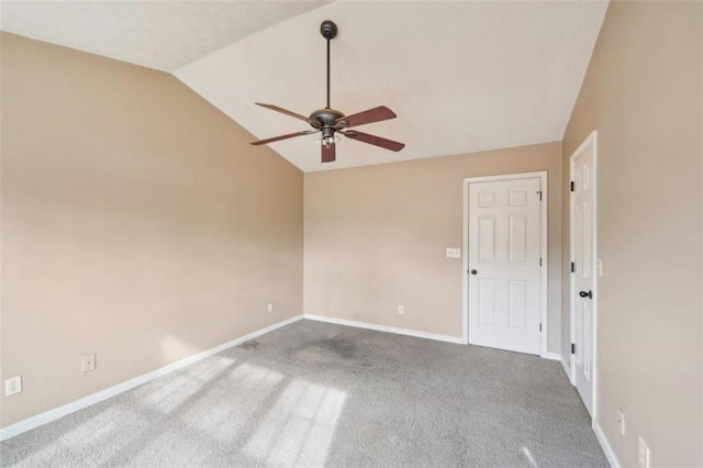 carpeted empty room featuring vaulted ceiling and ceiling fan