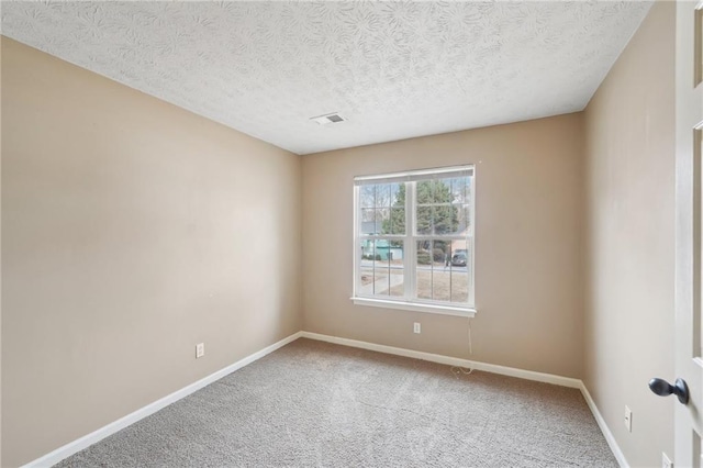 unfurnished room featuring carpet and a textured ceiling