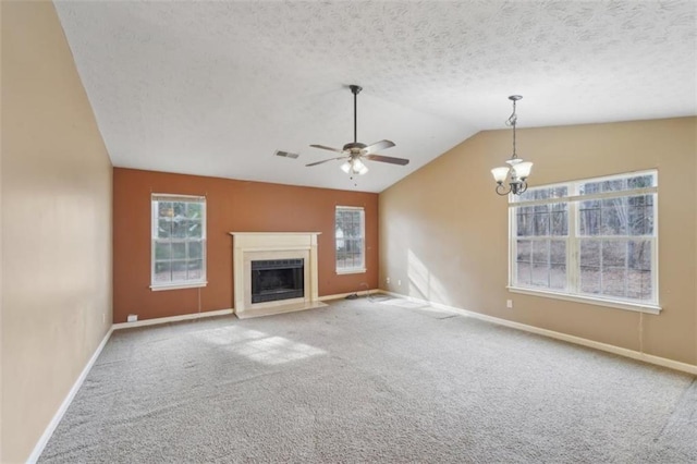 unfurnished living room featuring carpet floors, a textured ceiling, vaulted ceiling, and a healthy amount of sunlight