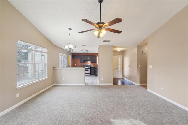 unfurnished living room with light colored carpet, lofted ceiling, and ceiling fan with notable chandelier