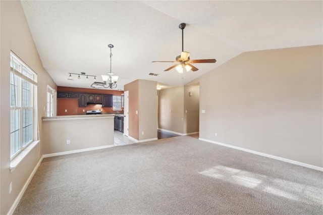 unfurnished living room featuring light colored carpet, lofted ceiling, track lighting, and ceiling fan with notable chandelier