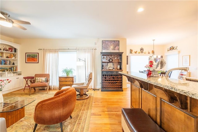 living area with light wood-type flooring and ceiling fan