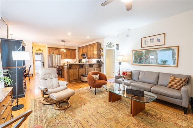 living area with light wood-style flooring, ceiling fan, and recessed lighting