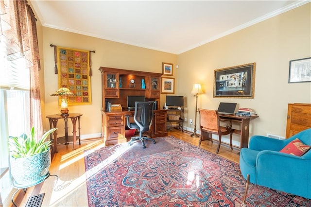 office space featuring wood finished floors, crown molding, and baseboards