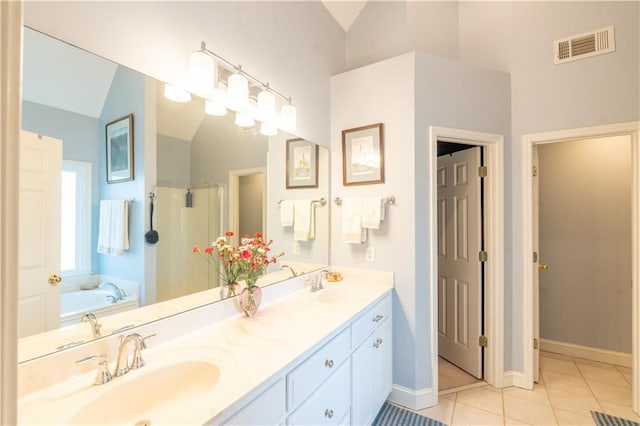 bathroom with lofted ceiling, tile patterned flooring, double vanity, baseboards, and a bath