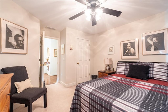bedroom featuring light colored carpet, baseboards, and ceiling fan
