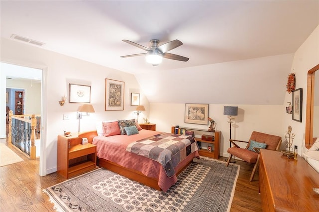 bedroom with wood finished floors, baseboards, ceiling fan, and lofted ceiling