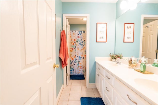 full bathroom featuring tile patterned flooring, double vanity, and baseboards