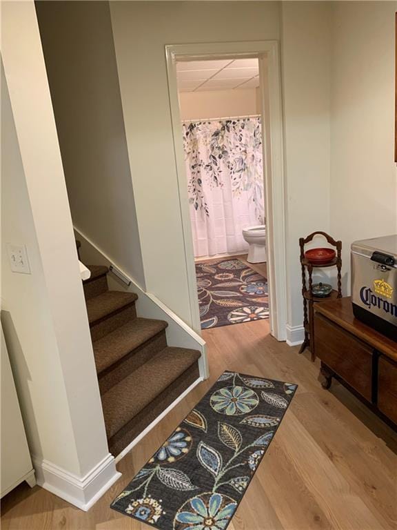 stairs with wood finished floors and baseboards