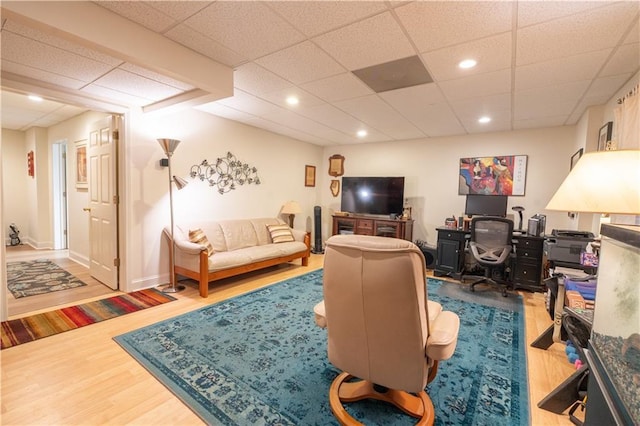 living room featuring wood finished floors, a desk, recessed lighting, and a paneled ceiling
