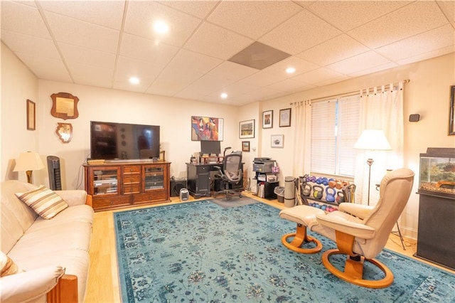 living room with a desk, wood finished floors, and a paneled ceiling