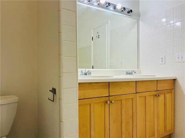 225 Magnolia Tree Ct, Johns Creek, GA 30022 - bathroom featuring toilet, double vanity, and tile walls