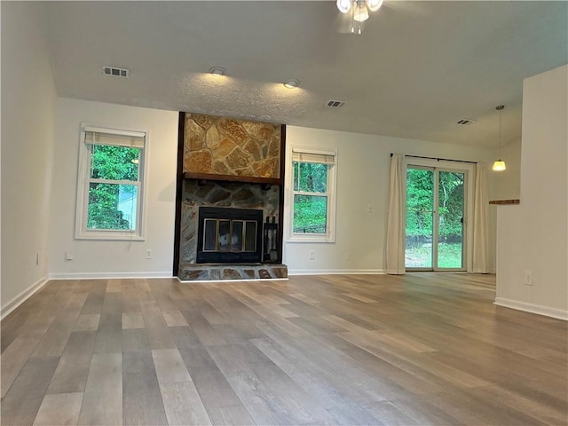 225 Magnolia Tree Ct, Johns Creek, GA 30022 - unfurnished living room with wood finished floors, baseboards, a ceiling fan, and a stone fireplace