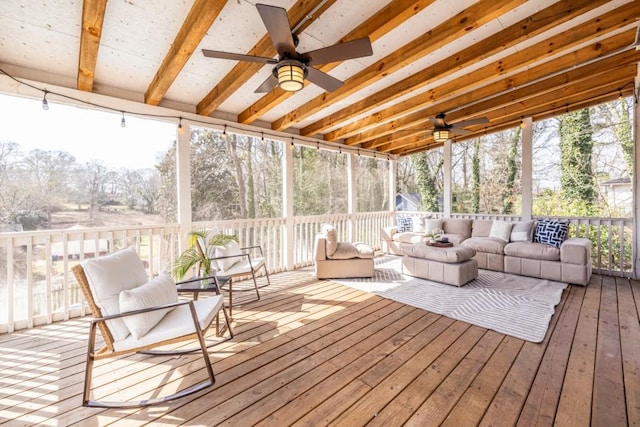 sunroom with a ceiling fan and beamed ceiling