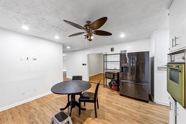 dining room with ceiling fan, a textured ceiling, and light hardwood / wood-style floors