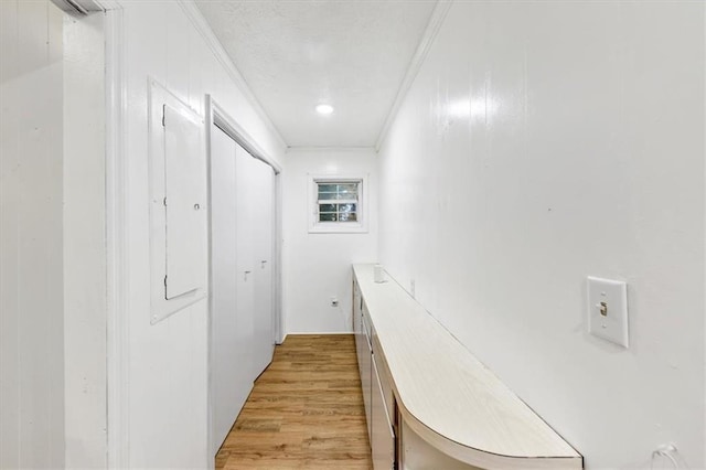 hallway with crown molding and light hardwood / wood-style floors