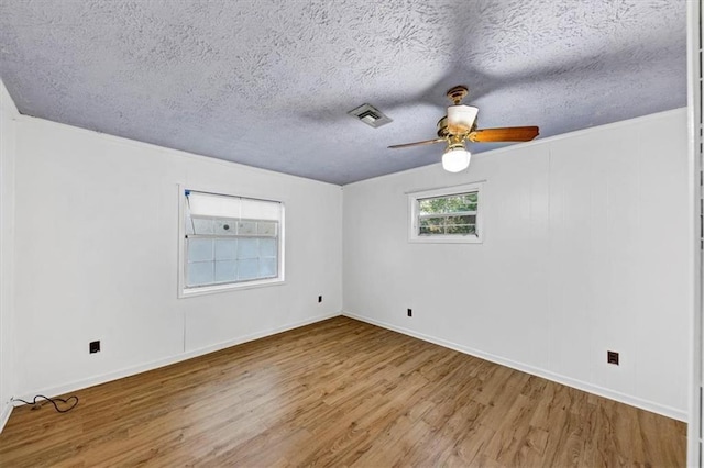 spare room featuring ceiling fan, wood-type flooring, and a textured ceiling