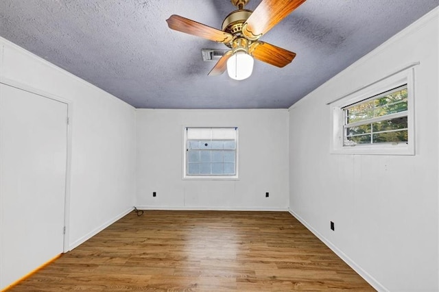 empty room featuring hardwood / wood-style floors, a textured ceiling, and ceiling fan