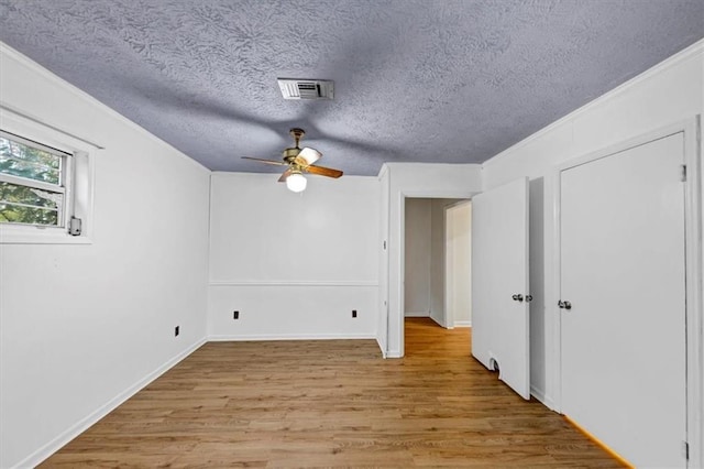 additional living space featuring ceiling fan, light hardwood / wood-style flooring, and a textured ceiling