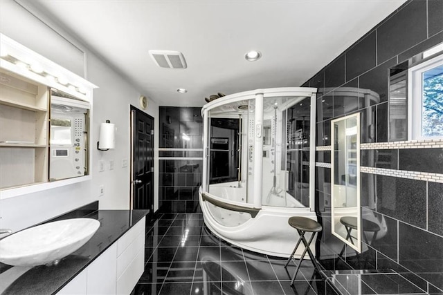 bathroom with vanity, a bathing tub, and tile walls