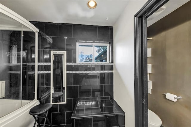 bathroom featuring tiled shower / bath combo and toilet