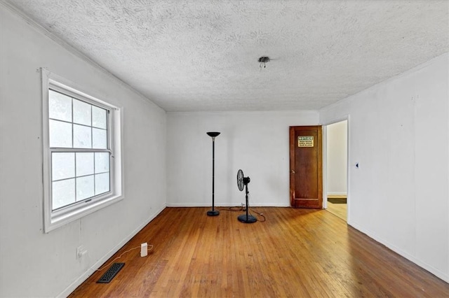 empty room featuring hardwood / wood-style flooring and a textured ceiling