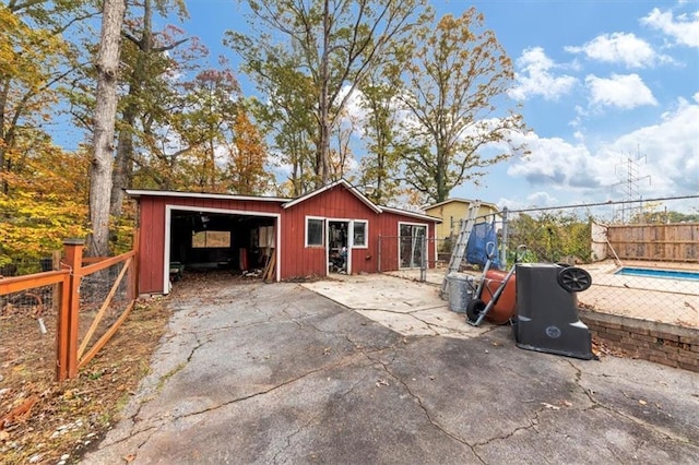 exterior space with a fenced in pool, a garage, and an outdoor structure