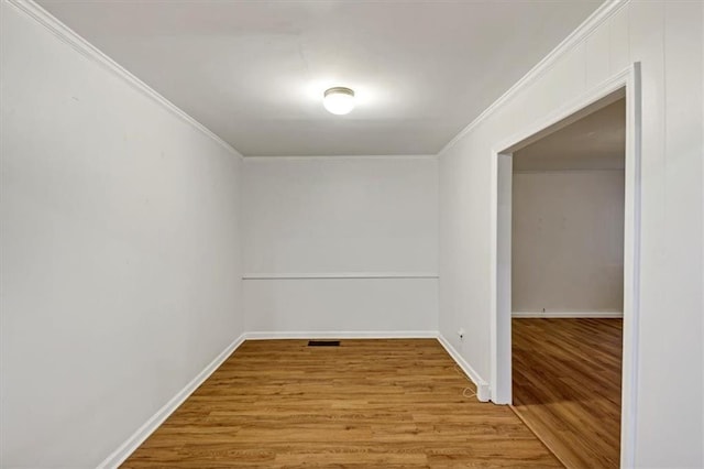 spare room featuring ornamental molding and light hardwood / wood-style floors