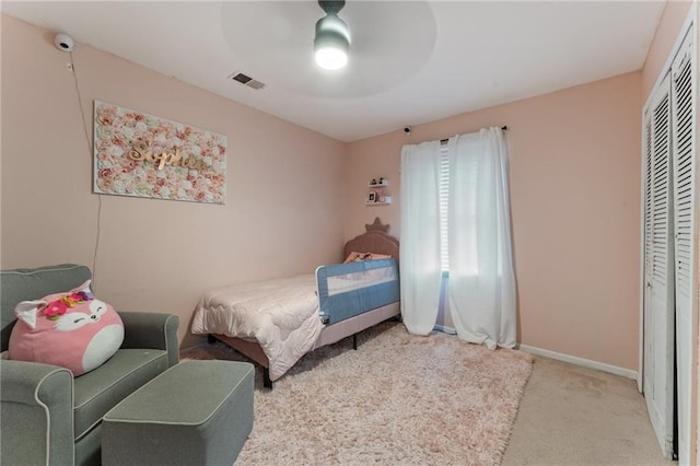 carpeted bedroom featuring baseboards, visible vents, a ceiling fan, and a closet