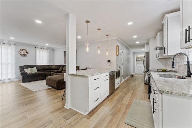 kitchen featuring recessed lighting, a sink, light wood-style floors, washer / clothes dryer, and white cabinets