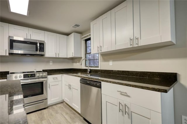 kitchen with sink, white cabinetry, and stainless steel appliances