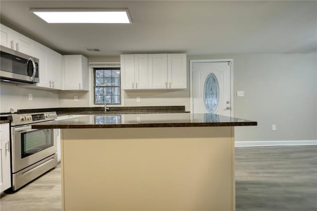 kitchen featuring a center island, white cabinets, light hardwood / wood-style floors, and appliances with stainless steel finishes