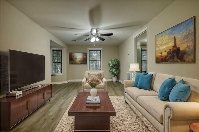 living room featuring ceiling fan and light hardwood / wood-style floors