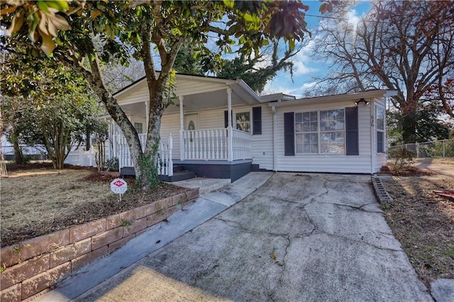 single story home with covered porch and fence