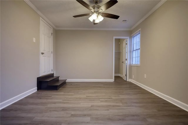 empty room with wood-type flooring, ceiling fan, and crown molding